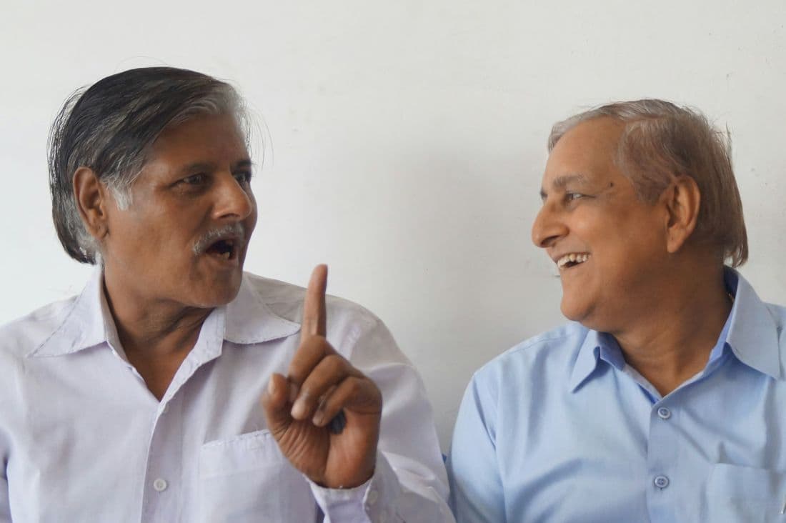 Two older men talking and smiling