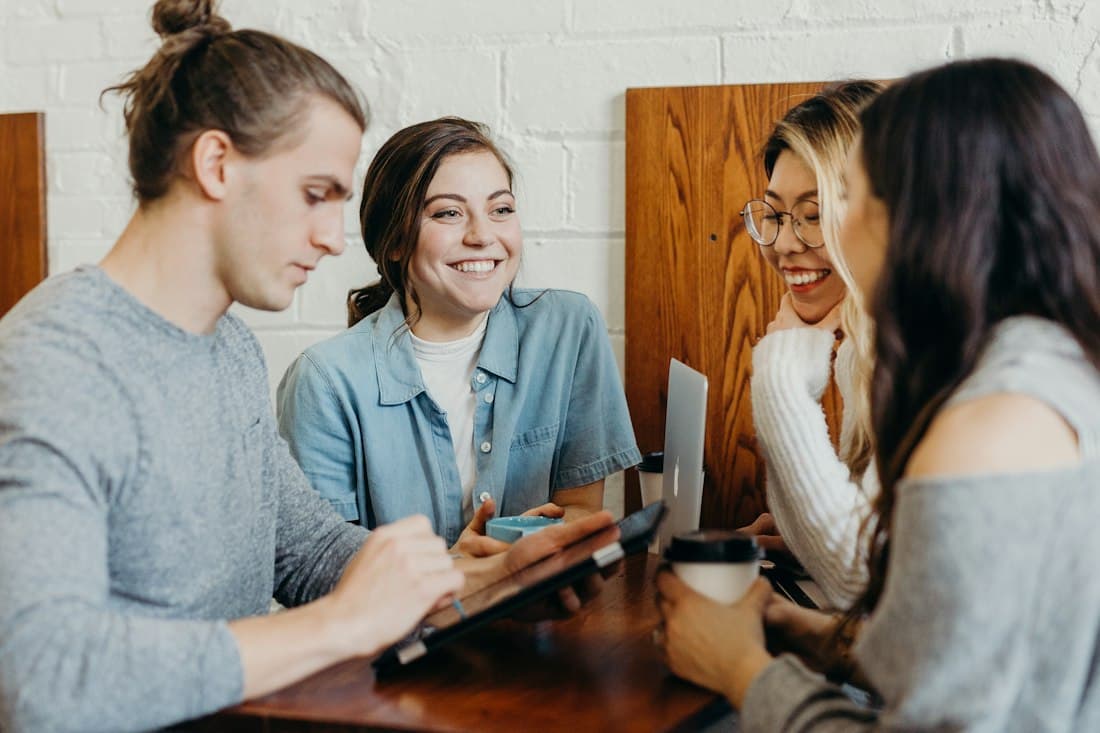 Vier Studierende arbeiten zusammen an einem Cafétisch